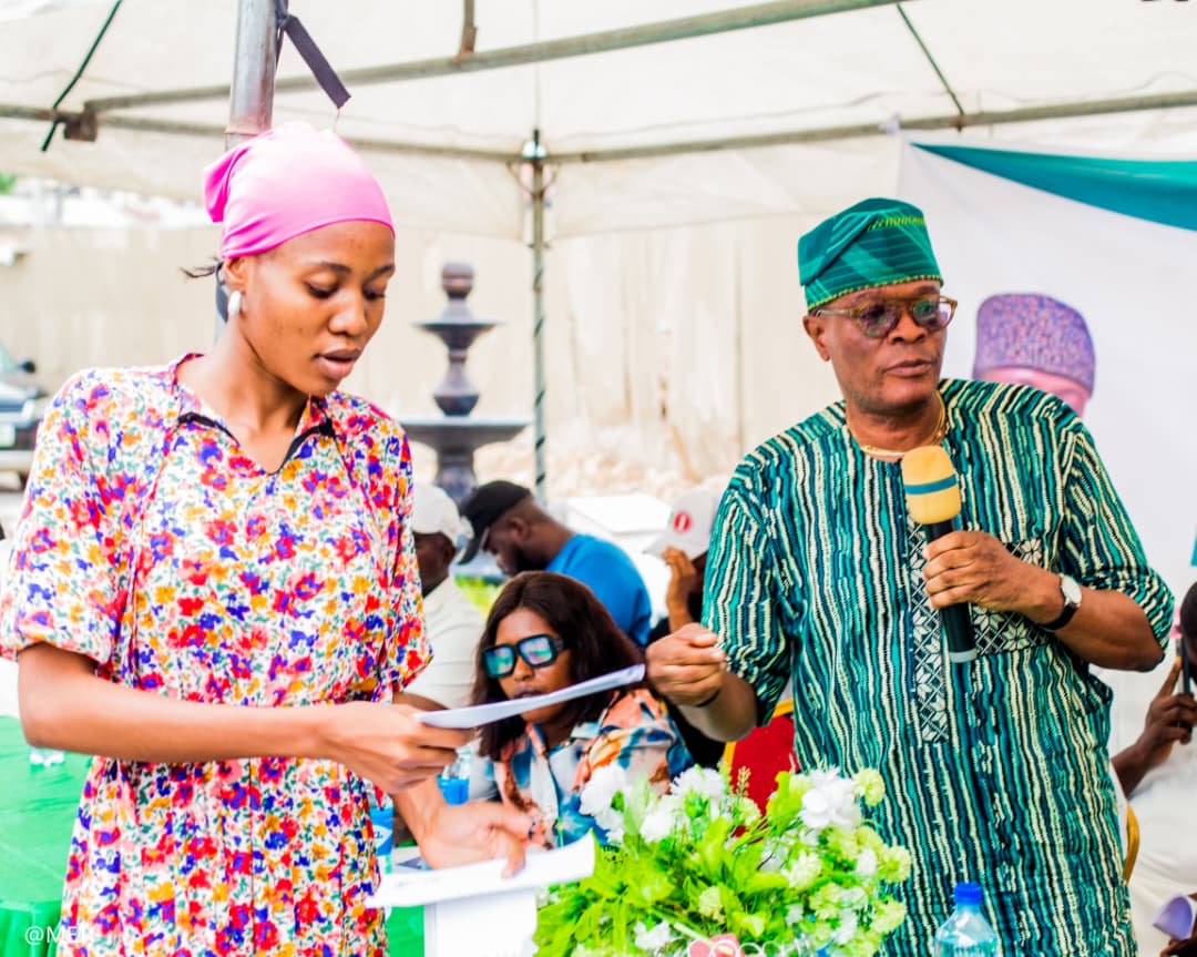 Programme officer confirming a beneficiary's details on stage