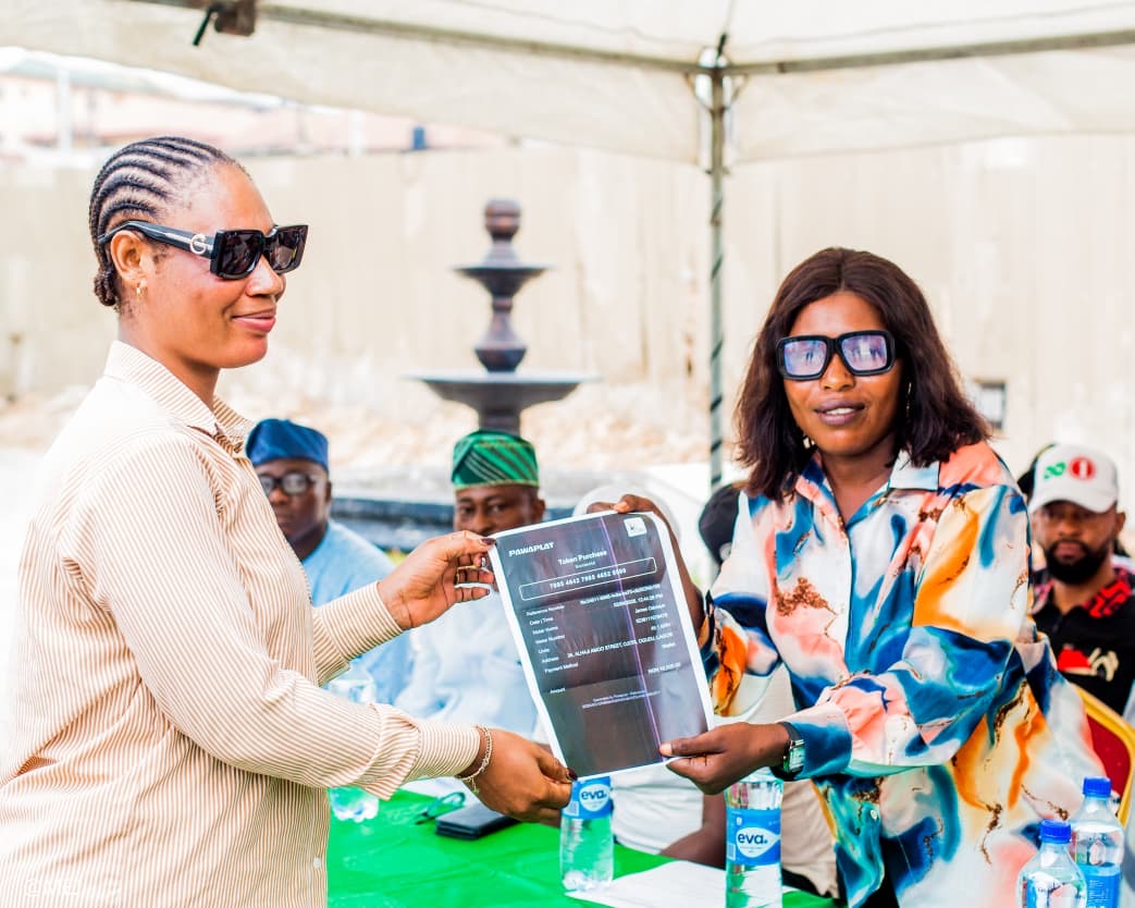 Two beneficiaries holding a PawaPlay token purchase receipt